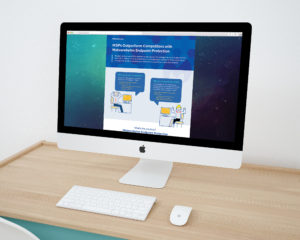 An iMac displays a website featuring an article titled "MSPs Outperform Competitors with Malwarebytes Endpoint Protection." The page shows two illustrated characters discussing security measures. The setup includes a keyboard and mouse on a wooden desk.